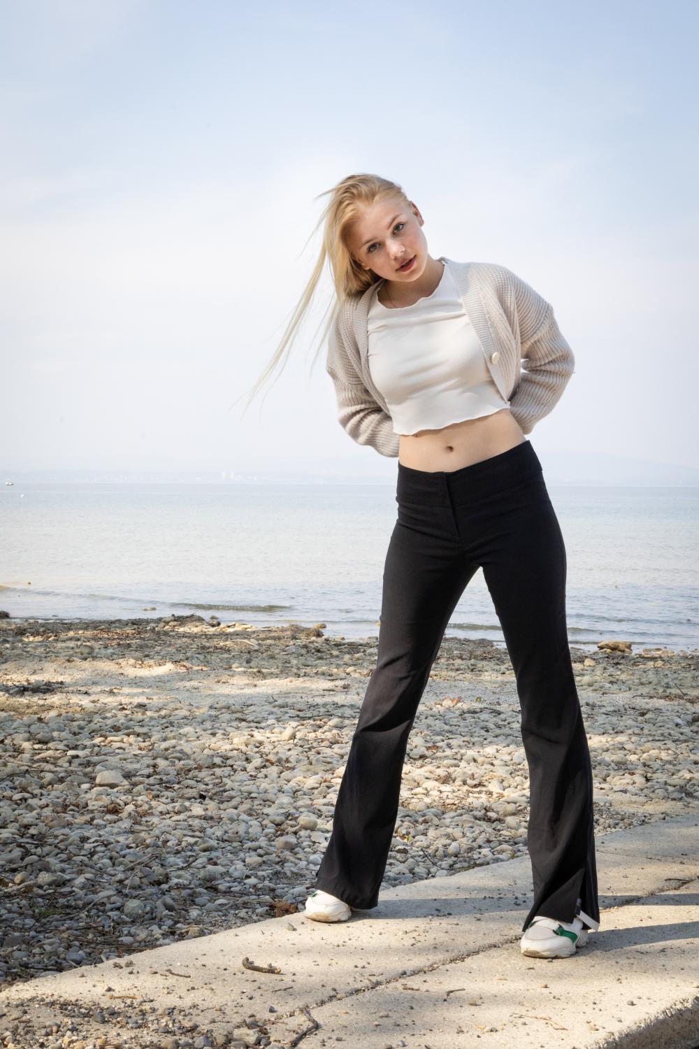 Photo of a young blonde woman, a lake in the background