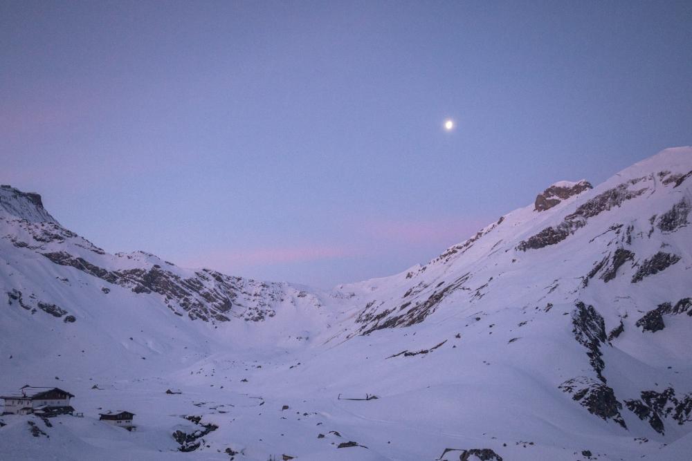 A snowy mountain range and the moon