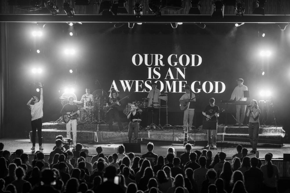 Concert Stage, Text on Screen : Our god is an awesome god